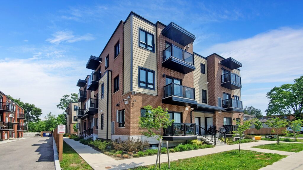 Apartment complex with multiple balconies on the second floor, showcasing a modern architectural design.