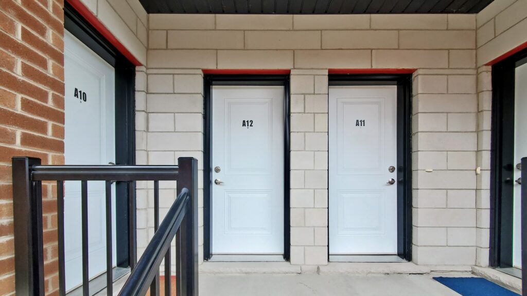 Two open doors on a brick building, inviting entry and showcasing the structure's architecture.