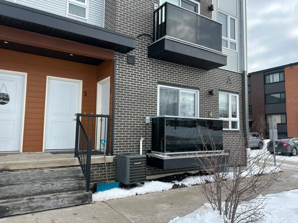 Two-story apartment building featuring a balcony and exterior stairs.