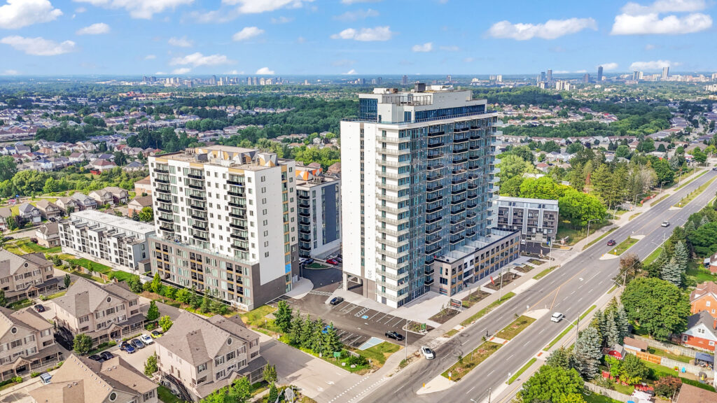 Aerial view of a modern apartment building surrounded by city streets and greenery.