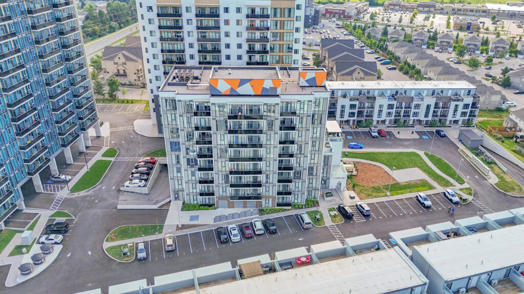 Aerial view of a large apartment complex surrounded by parking lots and green spaces.