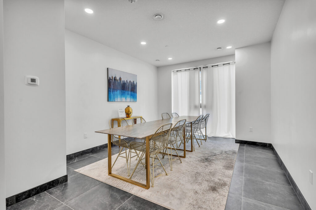 A dining room featuring a wooden table surrounded by four chairs. Soft lighting creates a warm atmosphere.