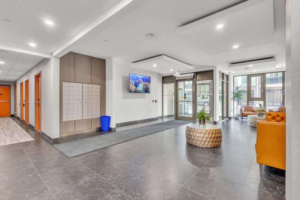 Modern apartment lobby featuring orange furniture and sleek design elements.