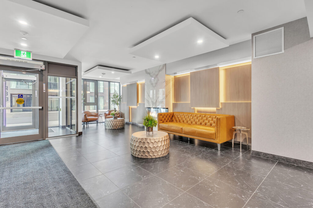 Lobby of a condo building featuring bright yellow couches and modern decor.