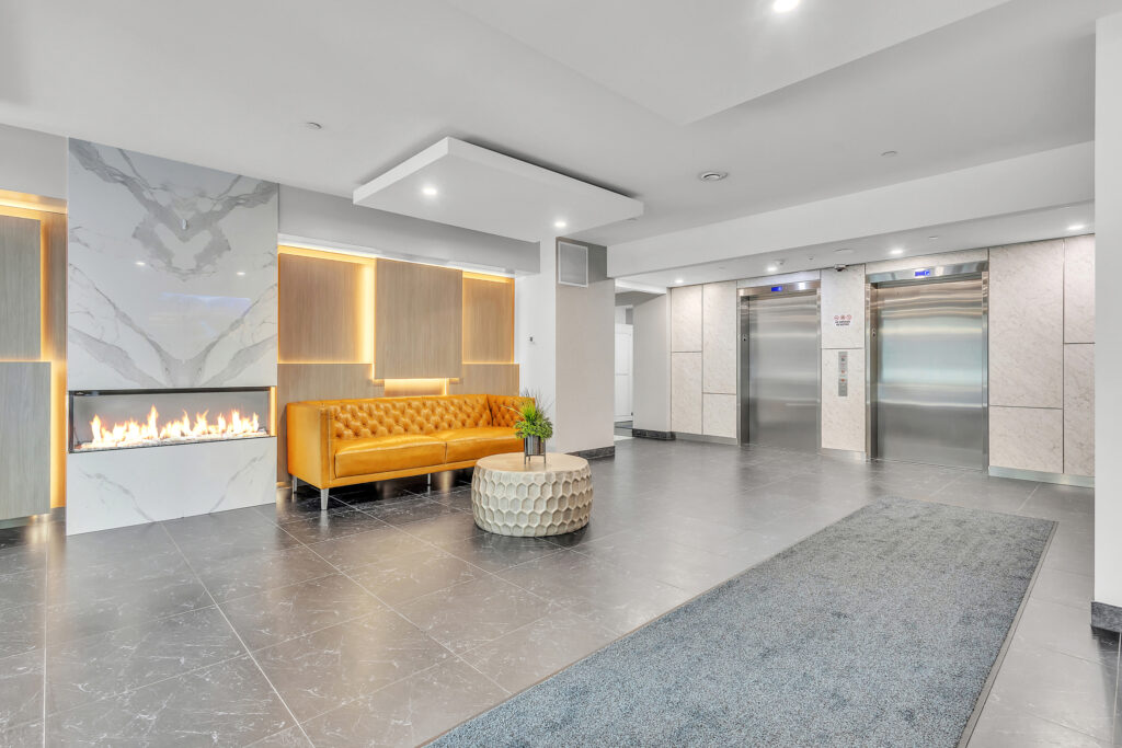 Modern lobby featuring a cozy fireplace and a comfortable couch for relaxation.