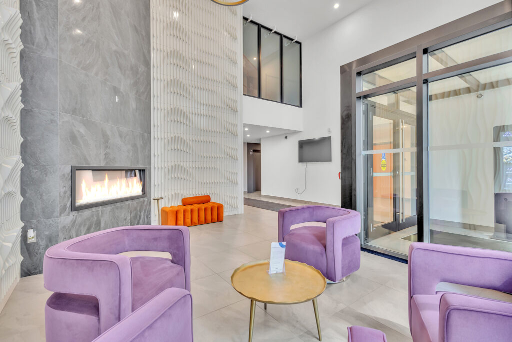 Modern apartment lobby featuring purple chairs and sleek decor.