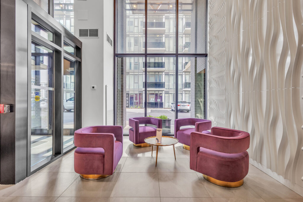 Modern lobby featuring purple chairs and a large window letting in natural light.