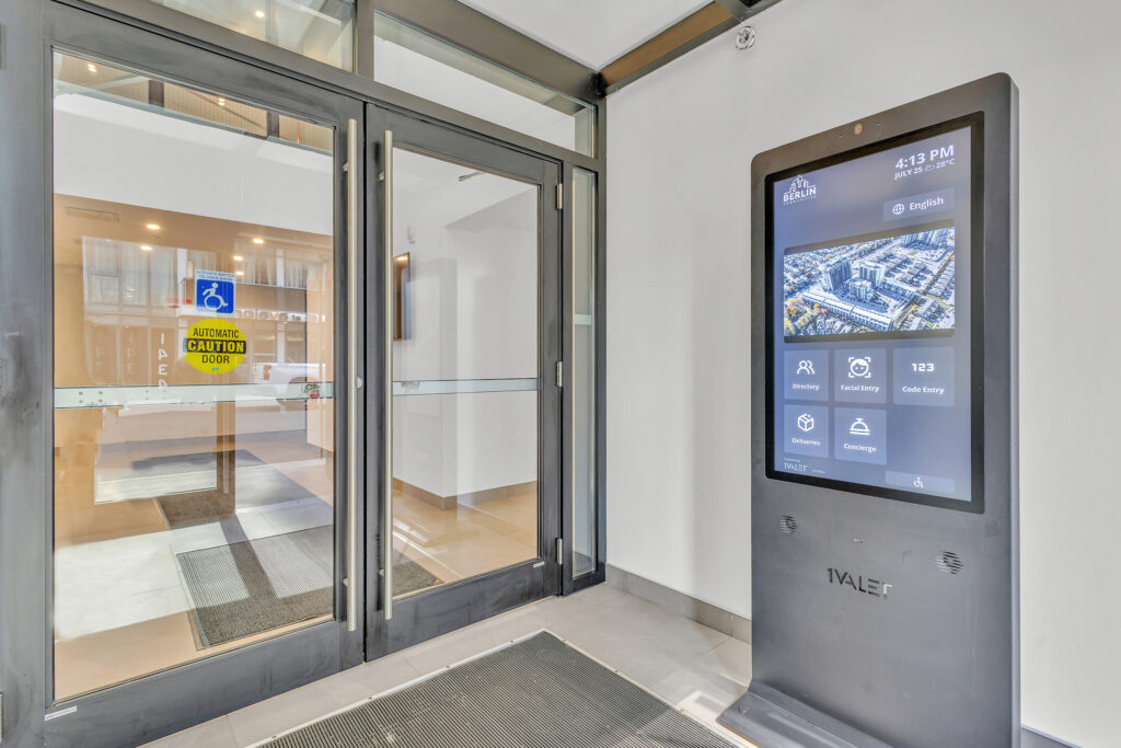 A large digital display in a building lobby showing information and announcements for visitors.