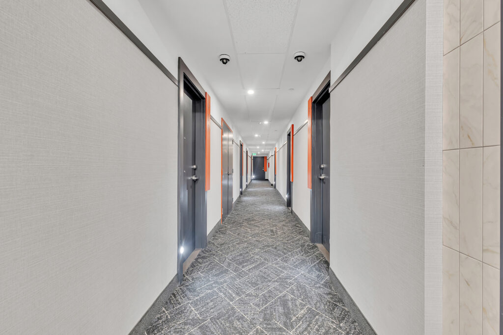 A long hallway featuring orange and white walls, creating a bright and inviting atmosphere.
