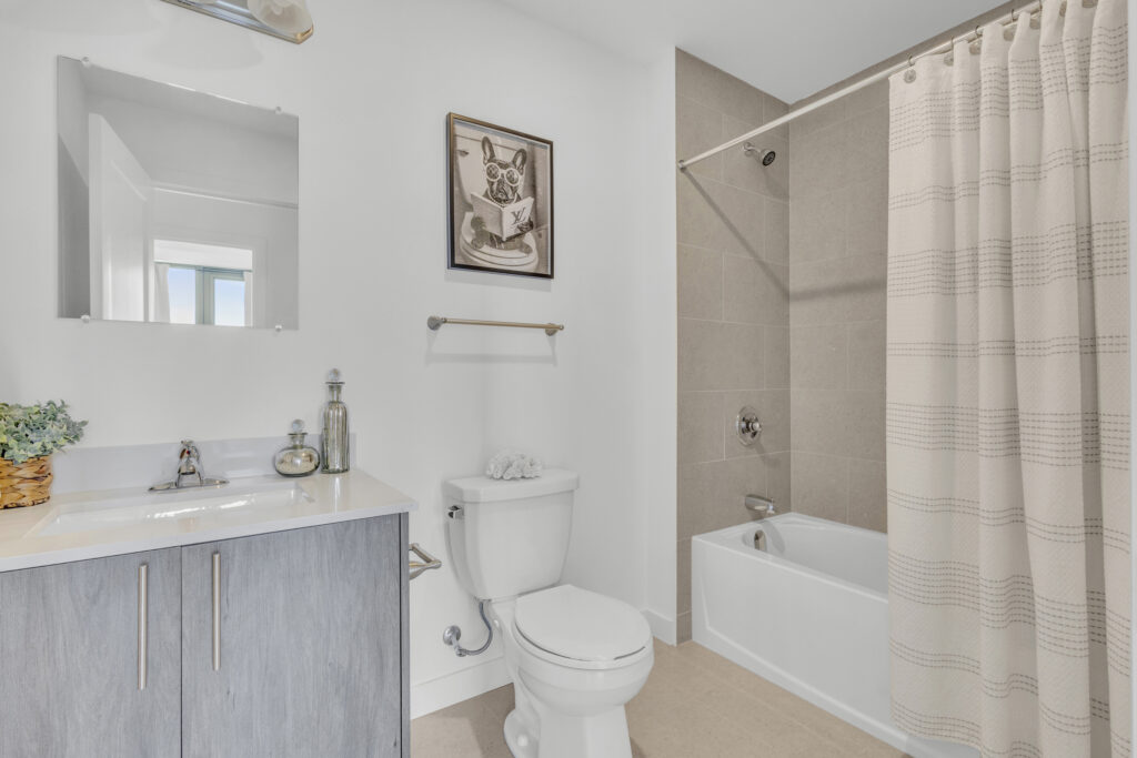 A bathroom featuring a toilet, sink, and a colorful shower curtain.
