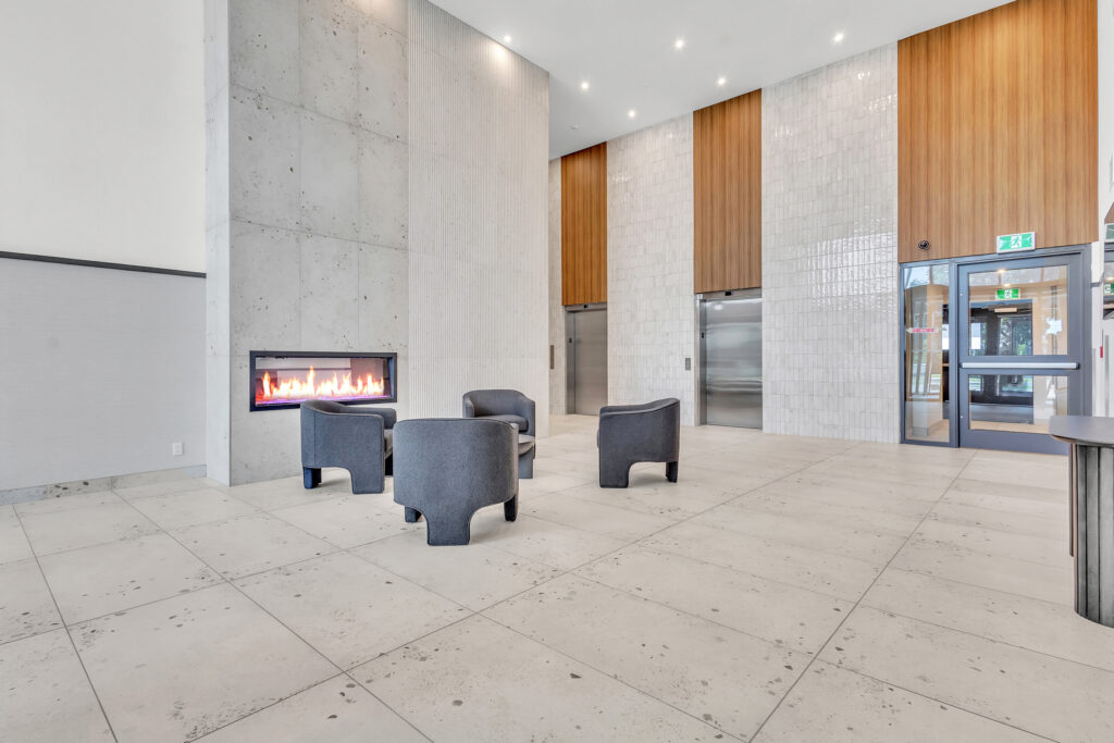 Modern lobby featuring comfortable chairs and a cozy fireplace for a welcoming atmosphere.