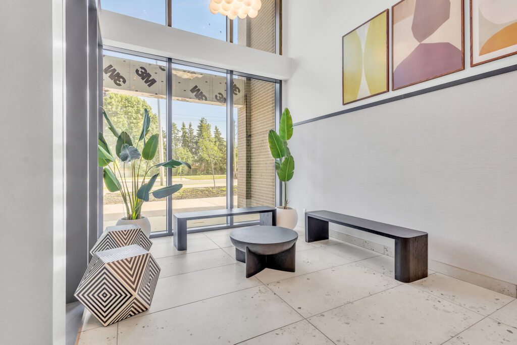 A modern hallway featuring a sleek bench and a large window letting in natural light.