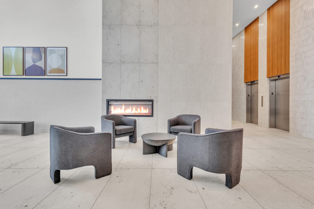 Modern lobby featuring comfortable chairs and a cozy fireplace for a welcoming atmosphere.