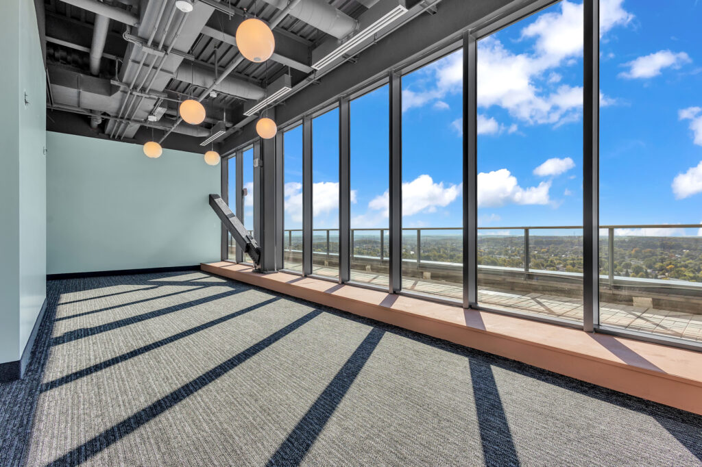 Empty office space with large windows showcasing a city view.