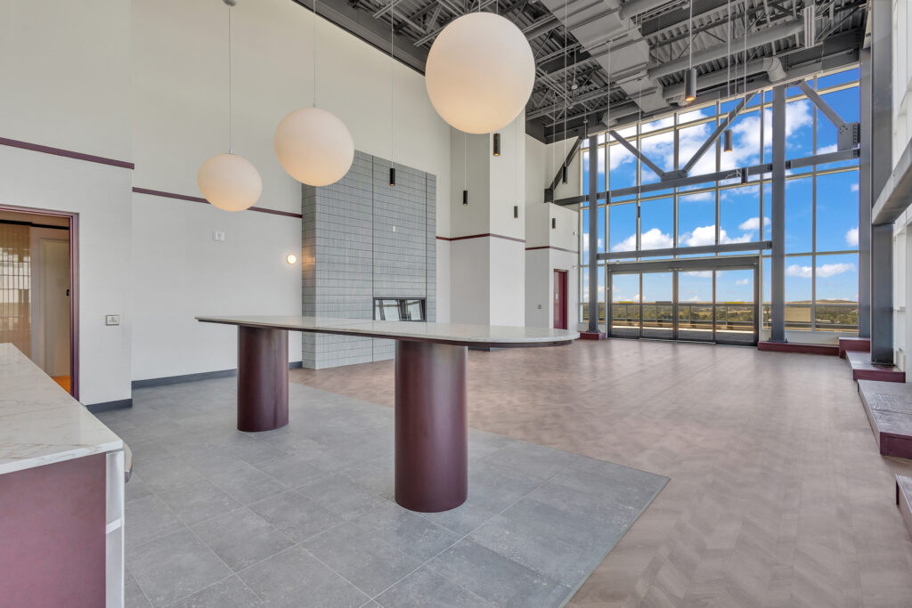 A modern kitchen with large windows showcasing a city skyline and waterfront view.