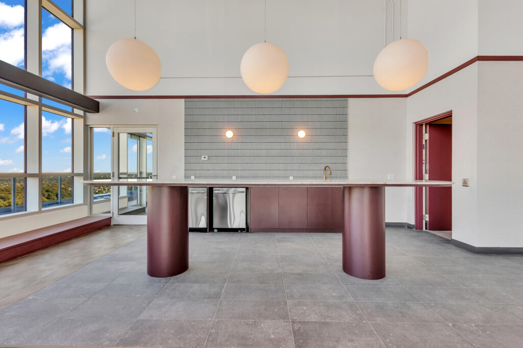 A spacious kitchen with modern appliances and a large window showcasing a city view.