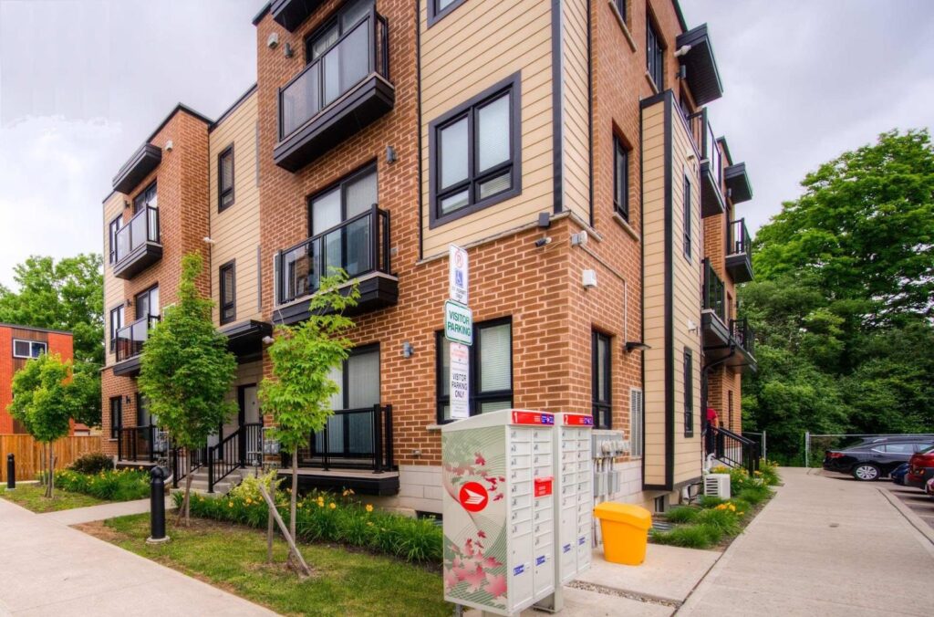 Apartment building with a mailbox in front and a sidewalk leading to the entrance.